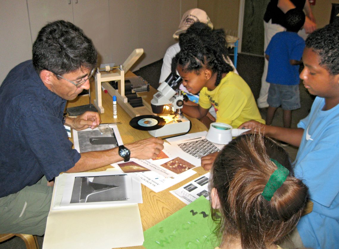 Scientist sharing research with children at Explora