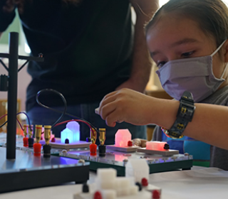 Child learning with smart grid exhibit at meet a scientist event