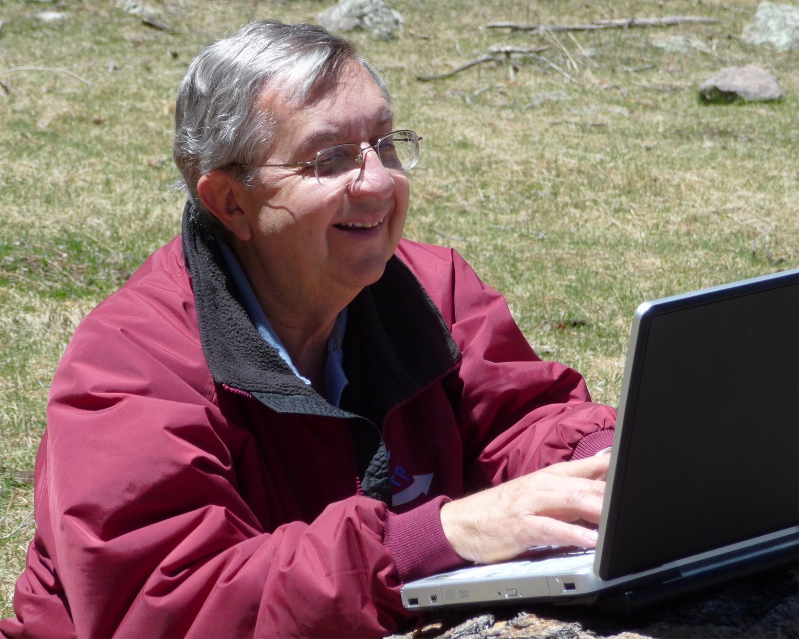 man typing on computer outside