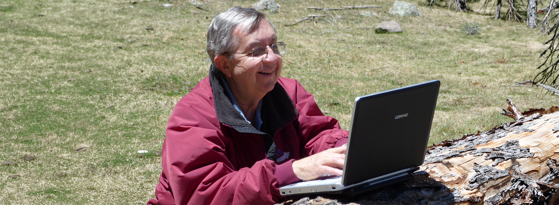 man typing on computer outside